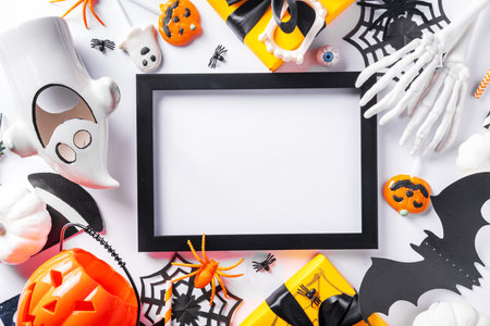 Happy Halloween holiday greeting card background. Flat lay gift boxes, set of Halloween symbols- spiders, bats, pumpkin, party decorations on white backgroundの写真素材