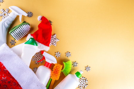 Christmas and winter cleaning flat lay. Various bottles, equipment, accessories for cleaning with christmas decor, snowflakes and Santa hat. Cleaning service advertising mockup background copy spaceの写真素材