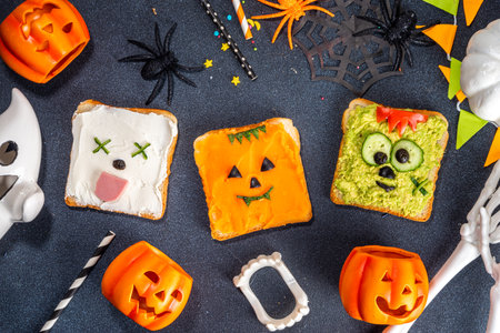 Kids food, party or breakfast Halloween idea. Simple healthy sandwiches recipe from toast bread, avocado, cream cheese, pumpkin spread with Halloween monster decorの写真素材