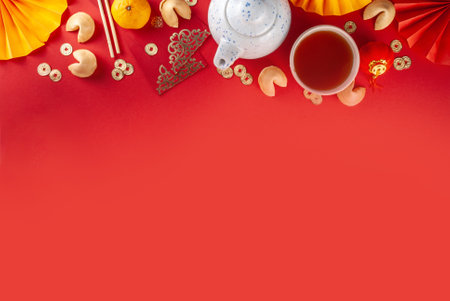 Chinese new year background. Red and golden yellow flatlay with traditional Chinese new year decor, envelopes with wishes, gold coins, fans, Chinese lanterns, oranges and teaの写真素材