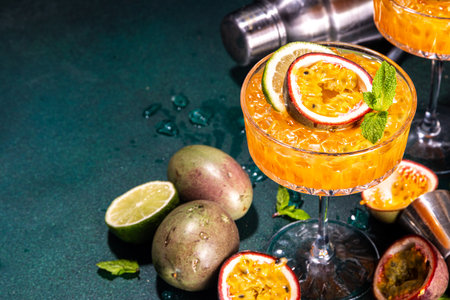 Passion fruit martini cocktail. Sweet pornstar alcoholic drink with fresh passion fruit and lime, with bar utensils copy spaceの写真素材