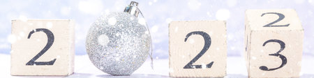 Block calendar with New 2023 Year Day countdown. Wooden cube turns from 2022 to 2023 on snowy snowy...