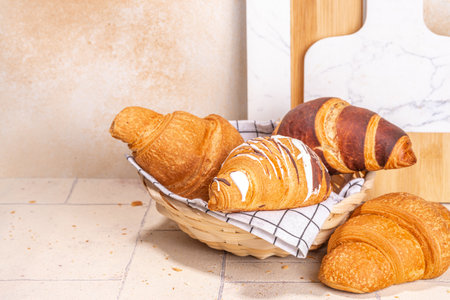 Freshly baked croissants with coffee espresso cup on beige tiled background top view copy spaceの写真素材