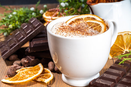 Orange hot cocoa drink. Homemade winter Christmas dark spicy hot chocolate with dried orange, with chocolate and orange slices on wooden cozy backgroundの写真素材