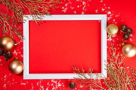 Red gold Christmas, New Year background with golden christmas tree twigs and balls, decorations, artificial snow, flat lay on red background copy spaceの写真素材