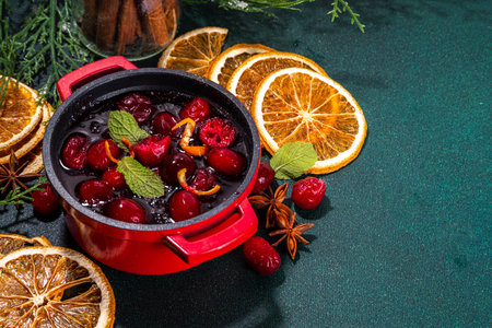 Homemade cranberry sauce with orange zest, spices and mint leaves, in small cooking pan, white wooden background copy spaceの写真素材