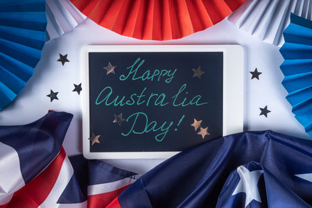 Australia Day greeting card Background with  australian flag, silver stars, with text Happy Australia day, paper red, blue, white decor, over white background copy spaceの写真素材