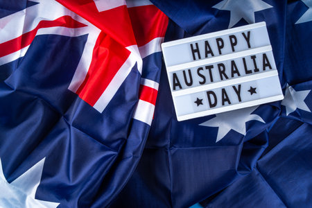 Australia Day greeting card Background with  australian flag, silver stars, lightbox with text Happy Australia day, paper red, blue, white decor, over blue background copy spaceの写真素材