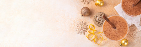 Eggnog Martini cocktail with cinnamon and nutmeg, with golden Christmas decorations and bokeh effect, copy spaceの写真素材