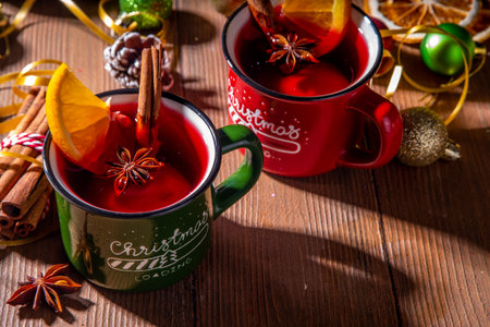 Christmas winter mulled wine drink. Classic style mulled red wine cocktail with orange slice, cinnamon, spices, on festive Christmas, New Year Noel decorated wooden background copy spaceの写真素材