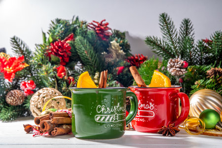 Christmas winter mulled wine drink. Classic style mulled red wine cocktail with orange slice, cinnamon, spices, on festive Christmas, New Year Noel decorated white wooden background copy spaceの写真素材