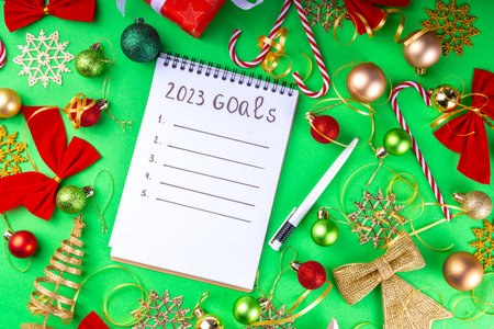 Notebook with New's Year Resolutions massage, with Christmas ornaments and decor. New Year goals List 2023, plan listing of new year beginnings goals and resolutions setting. Flat lay copy spaceの写真素材