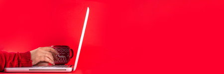 Side banner with woman hands, white laptop computer, headphones, big cup for hot chocolate. Christmas mood and vibe, listen to traditional new year songs music. Preparation for Christmas backgroundの写真素材