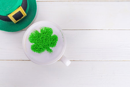Simple background for St. Patrick's Day. Cup of cappuccino latte coffee with whipped milk foam and...