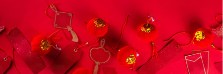 Chinese new year background, with festive Chinese lanterns, paper fans and traditional New Year stripes posters for wishes on bright red background copy spaceの写真素材