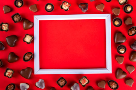 Valentines Day chocolates banner, background, frame. Various sweets and chocolate candy on red paper...
