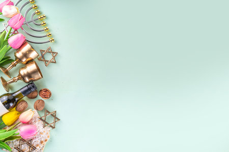 Passover, Pesah background. jewish Easter Passover spring holiday celebration, with accessories - menorah, matzo, spring flowers, wine bottle, gold wine glass, jewish david stars, copy space top viewの写真素材