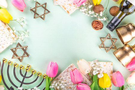 Passover, Pesah background. jewish Easter Passover spring holiday celebration, with accessories - menorah, matzo, spring flowers, wine bottle, gold wine glass, jewish david stars, copy space top viewの写真素材