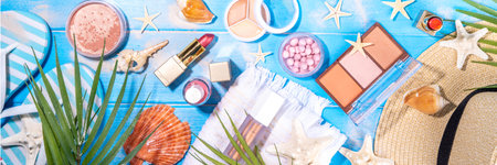 Summer make-up cosmetics flat lay, Vacation, Holiday shopping sale make up.Shadows, lipstick, mascara, face powder, blush on blue wooden background with summer accessories, starfish, shellsの写真素材