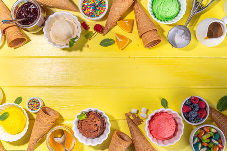 Ice cream festival background, Summer ice cream buffet with various gelato sundaes flavors. sweet toppings and sprinkles, high-colored yellow wooden background to view copy spaceの写真素材