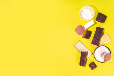 Set of various energy protein bar. Different taste of protein bars and snacks, with protein protein powder jar on high colored background copy spaceの写真素材