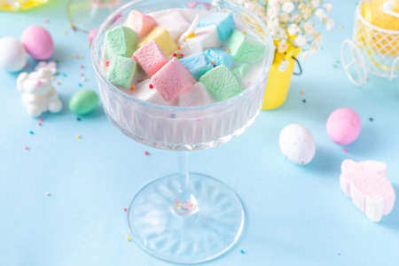Colorful pastel colored kids Easter party mocktails, Creamy and iced non-alcohol drinks with cotton candy, marshmallow, sugar sprinkles and Easter eggs, on blue pink pastel background copy spaceの写真素材