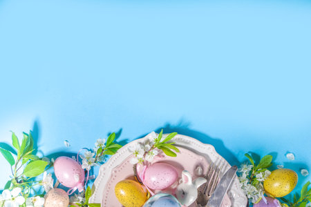 Easter table setting decoration, with colorful Easter eggs, spring garden blossom flower, bunny...
