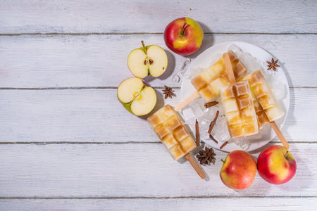 Apple pie ice cream  on a stick. Homemade lollipops with apple pie spicy flavor, on wooden table backgroundの写真素材