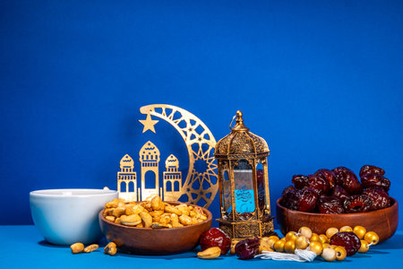 Ramadan muslim holiday background, with traditional treats - dates, nuts, dried fruits, sweets, religion rosary beads, lantern, tea, islamic Mosque, crescent moon Ramadan Kareem themed decorationsの写真素材