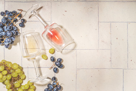 Wineglasses of red and white wine on beige tiled backgroundの写真素材