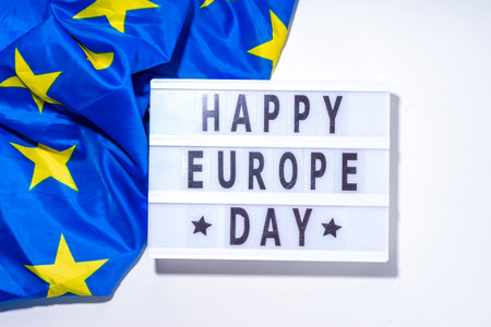 Happy Europe Day simple background, lightbox sign with inscription text Happy Europe Day, flags of Europe (European Union), on white background top view flat lay copy spaceの写真素材