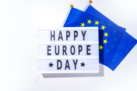 Happy Europe Day simple background, lightbox sign with inscription text Happy Europe Day, flags of Europe (European Union), on white background top view flat lay copy spaceの写真素材
