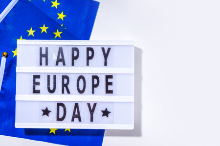 Happy Europe Day simple background, lightbox sign with inscription text Happy Europe Day, flags of Europe (European Union), on white background top view flat lay copy spaceの写真素材