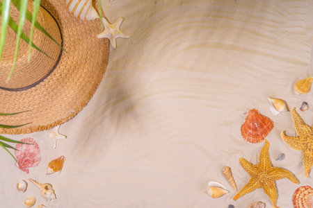 Summer sunny sand flat lay with straw hat, flip flops and seashells, on sea sand background copy...