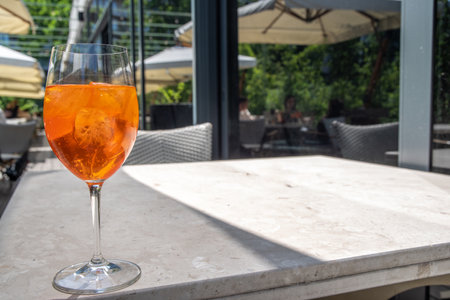 Girl drink iced alcohol Aperol spritz cocktail on summer terrace, in cafe or restaurantの写真素材