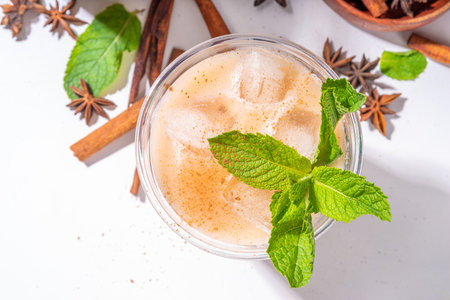 Thai Iced tea, asian indian masala spices drink with non-dairy coconut whipped milk, ice cubes and mint leaves, copy spaceの写真素材