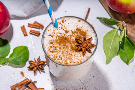 Apple pie smoothie with yogurt, apple slices, oatmeal granola flakes, cinnamon, spices and walnuts. Healthy uatumn breakfast or snack, with fresh raw apples and spices copy spaceの写真素材