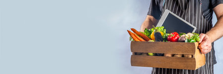 Farm organic market shopping concept, Wooden box with summer, autumn raw vegetables and fruits, in farmer mans hands on white backgroundの写真素材
