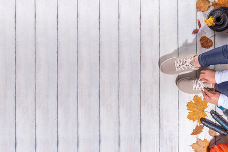 Autumn sport fitness background. Outdoors fall workouts concept. Running sneakers, dumbbell barbell discs, jump rope, water bottle, wooden background, with autumn leaves, pumpkins top view copy spaceの写真素材