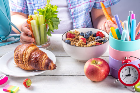 Healthy nutritious  morning breakfast for school kids, with fresh fruits, vegetables, croissant, muesli, milk and sandwich. Child girl having breakfast before school and work, copy spaceの写真素材