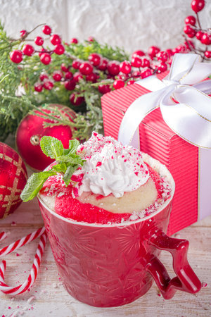 Candy cane peppermint mugcake. Simple Christmas breakfast, snack idea recipe, white and red swirled sponge cake in festive mugs with whipped cream and candy cane pieces toppingの写真素材