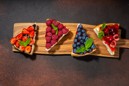 Summer cafe baking menu background, sweet cheesecake portion slices with various toppings, jam and berry fruits - strawberry, blueberry, raspberry, cherryの写真素材