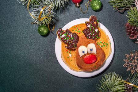 Funny pancakes in shapes of deer, Christmas tree, Christmas wreath made of fresh fruits, berries, chocolate paste. Healthy breakfast food for kids ideas. top viewの写真素材