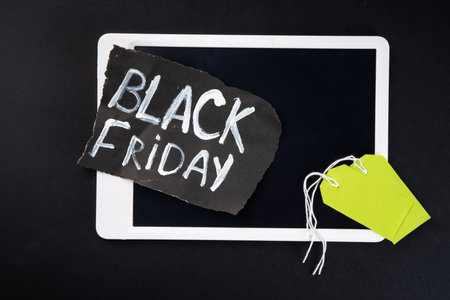 Black friday sale background with sale tags, clothes, laptop, headphones, smartphone, tablet, sale items, flat lay top view copy spaceの写真素材