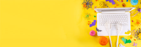 Funny high-colored Halloween bright yellow composition. White laptop with typing hands,  Halloween...