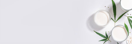 Cannabis milk. Non-dairy lactose free vegan milk from hemp seeds, on white background of cannabis leaves, industrial use of marijuana. Legal use of hemp product concept.の写真素材