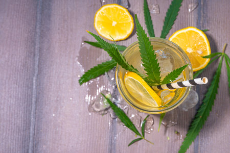 Cannabis hemp cold lemonade drink, Alternative cold mojito lemon drink with marijuana extract and leaves, legal industrial hemp use concept. CBD infused fruit waterの写真素材