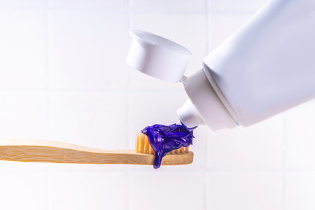 Trendy whitening purple Toothpaste, korean asian toothpaste with toothbrush and white unrecognizable tooth cleaning paste tube copy spaceの写真素材