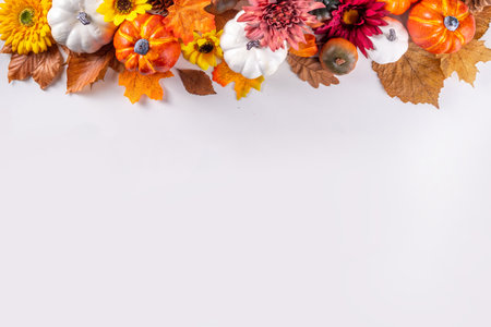 Autumn holidays and sale background. Thanksgiving Day greetings card. Multi-colored pumpkins, autumn leaves and flowers, acorn cones, decor on a white background top view copy spaceの写真素材