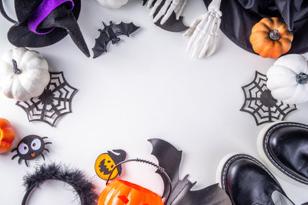 Preparations for kids's Halloween party, trick or treat tradition. Traditional children's Halloween costume witch, ghost, skeleton, pumpkin accessories, with candy bucket, decor on white backgroundの写真素材